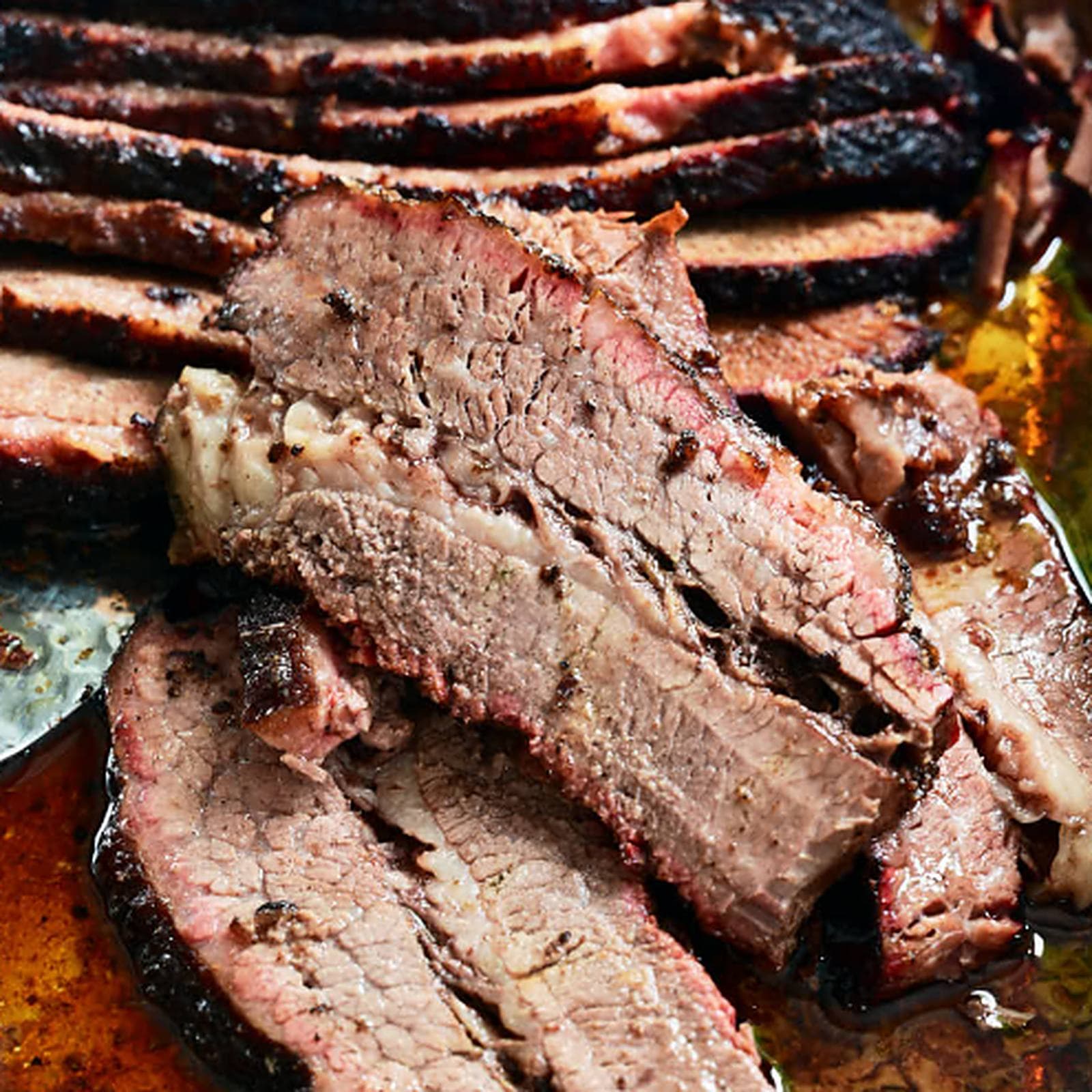 Sliced smoked brisket resting in its own juices